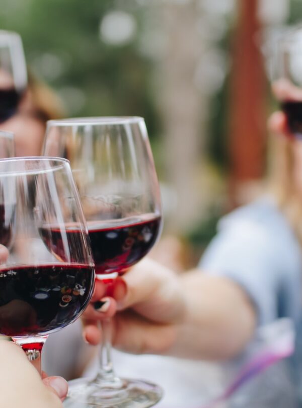 people tossing their clear wine glasses