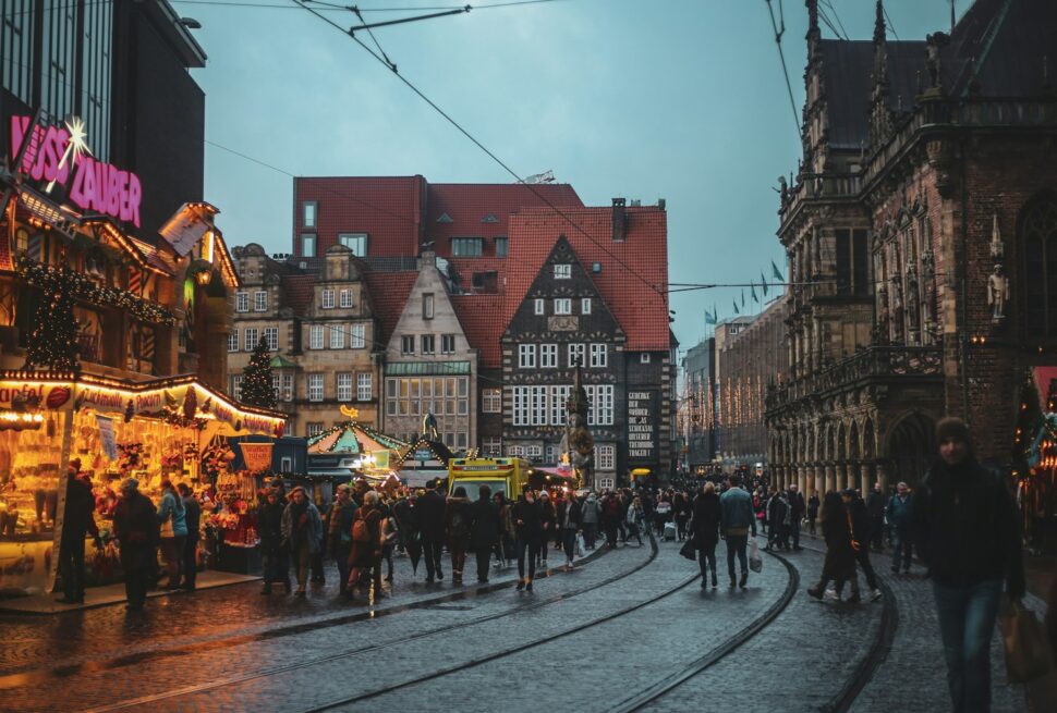 a crowd of people walking down a street next to tall buildings
