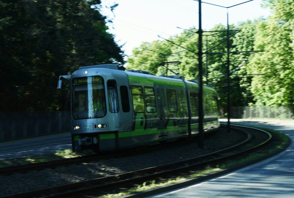 a green and white train traveling down train tracks