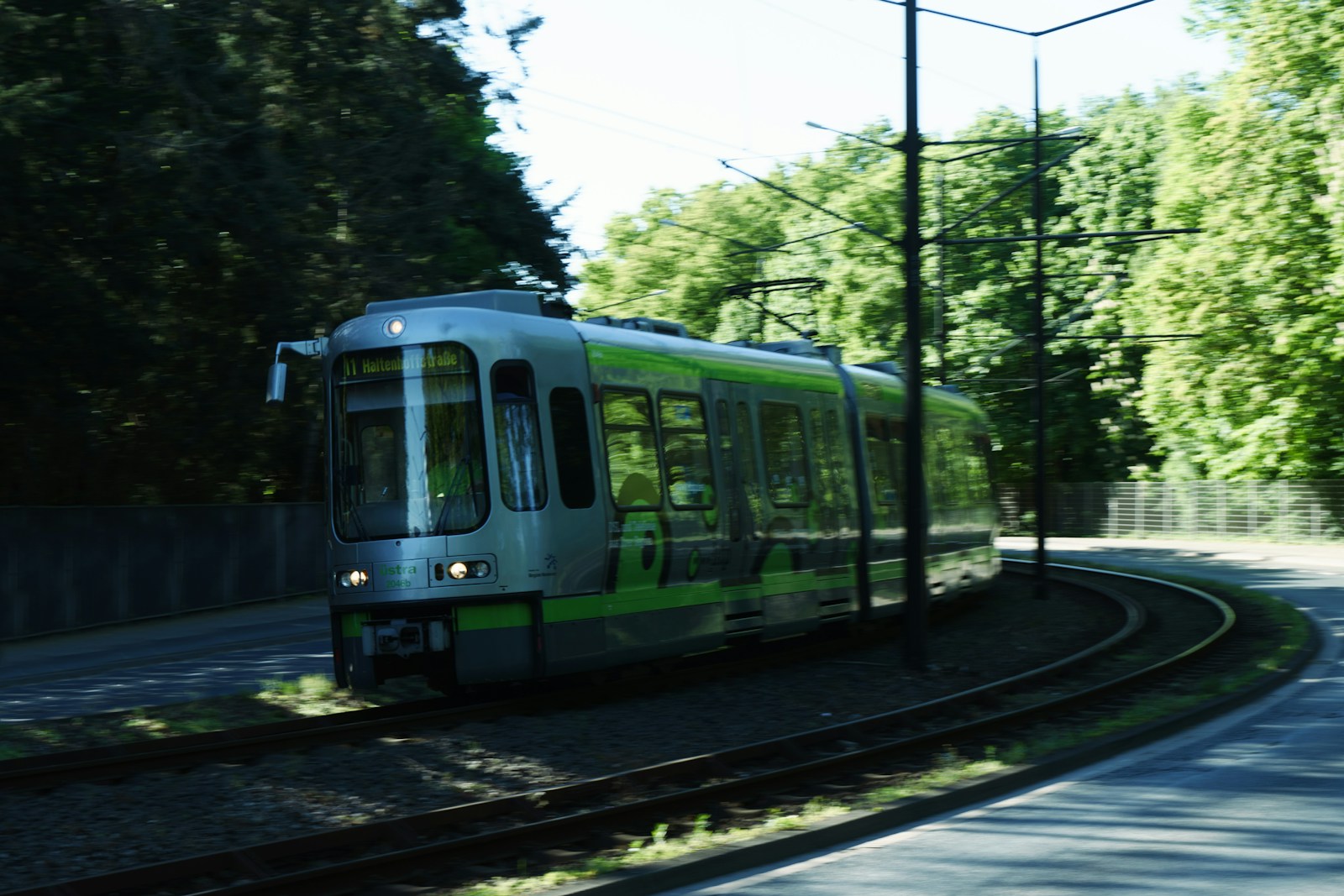 a green and white train traveling down train tracks